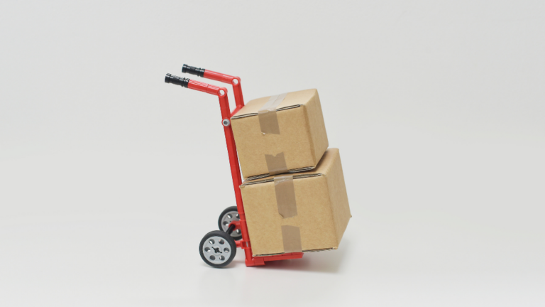Two boxes stacked on a hand-pushed trolley. It sits alone with no one around it.